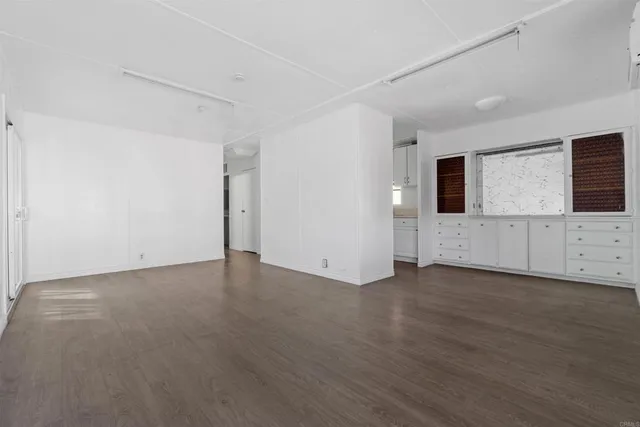 a view of a livingroom with wooden floor and cabinet