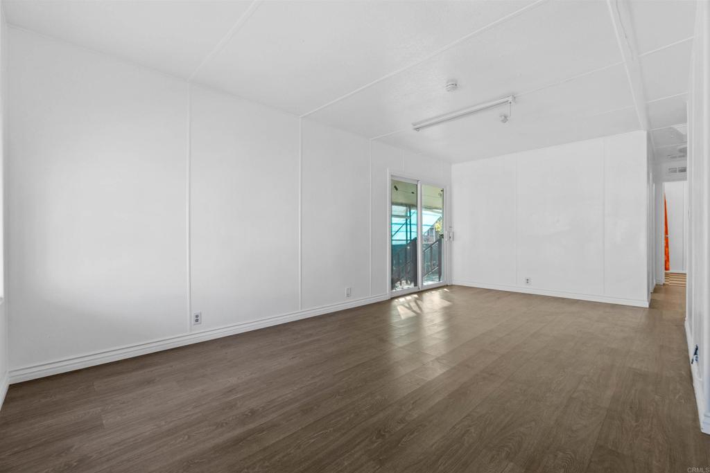 12044 Royal Road, Unit 93 El Cajon, CA 92021 - Photo 10 of 29 an empty room with wooden floor and windows