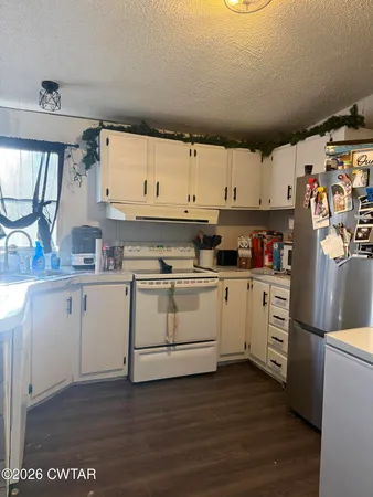 a kitchen with white cabinets and white appliances