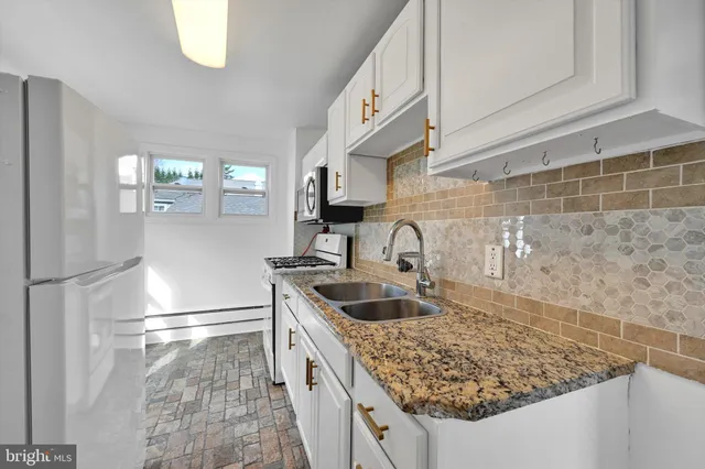 a kitchen with granite countertop a sink and a refrigerator