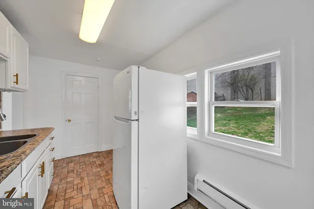 a kitchen with a refrigerator a stove a microwave and window