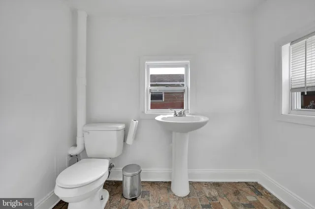 a bathroom with a sink toilet and a mirror