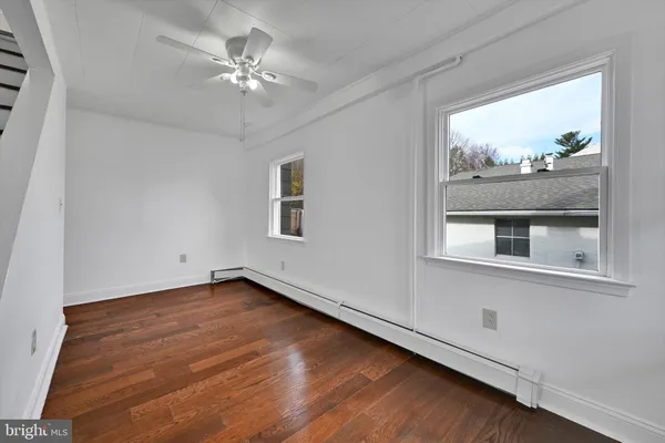 a view of an empty room with a window and a chandelier fan