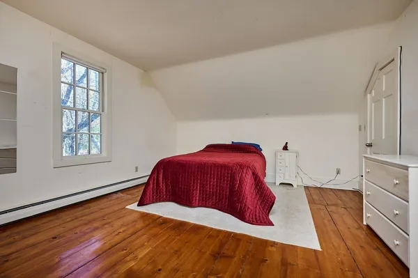 a bedroom with a bed chair and window