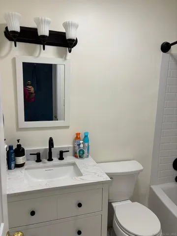 a bathroom with a toilet sink and mirror