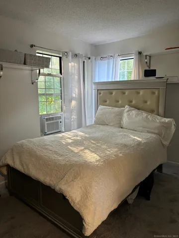 a bed sitting in a bedroom next to a window