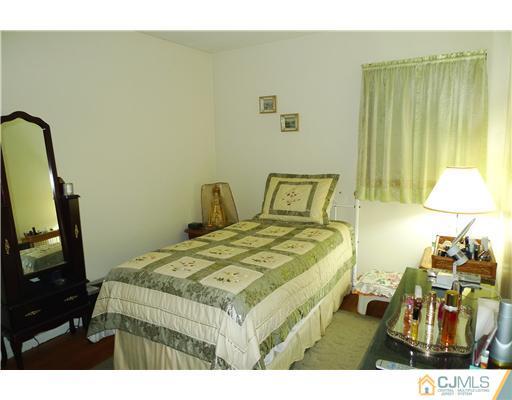 101 Stelton Road Piscataway, NJ 08854 - Photo 10 of 13 a bedroom with a bed and a flat tv screen on the dresser
