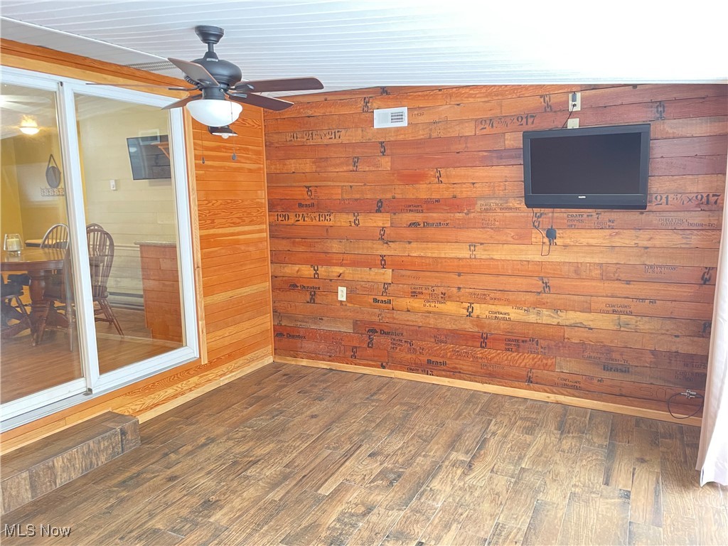 1381 Robb Road Conneaut, OH 44030 - Photo 34 of 50 Heated 3 seasons room featuring wood walls, dark wood-style floors, and a ceiling fan