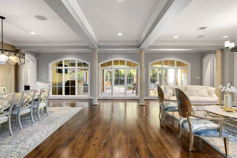 a living room with furniture a fireplace and a chandelier