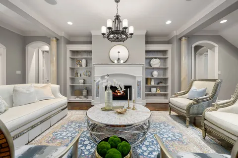 a living room with furniture a chandelier and a dining table