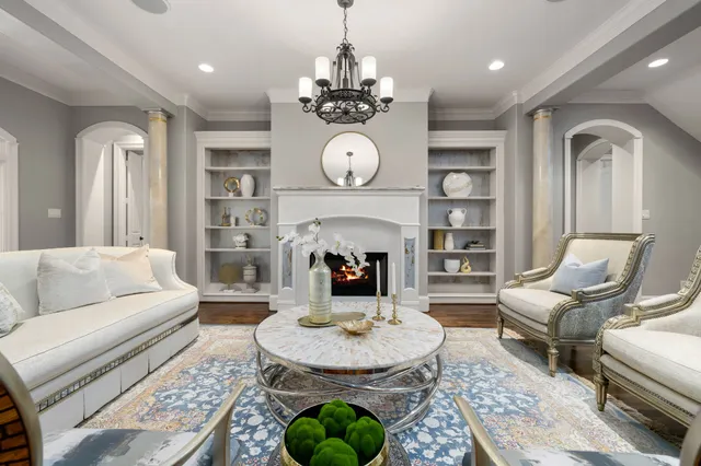 a living room with furniture a chandelier and a dining table