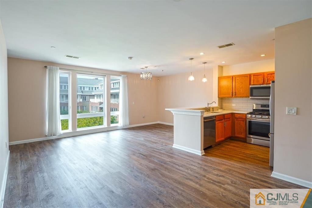 368 Rector Street, Unit 511 Perth Amboy, NJ 08861 - Photo 2 of 16 a view of kitchen with kitchen island wooden floors and stainless steel appliances