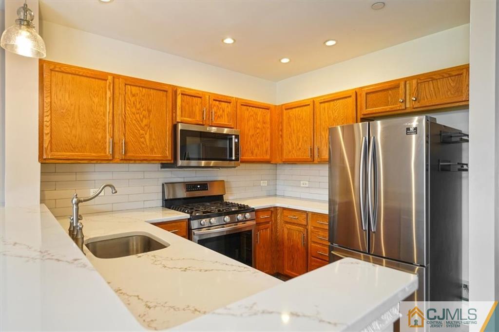 368 Rector Street, Unit 511 Perth Amboy, NJ 08861 - Photo 6 of 16 a kitchen with stainless steel appliances a refrigerator sink and microwave