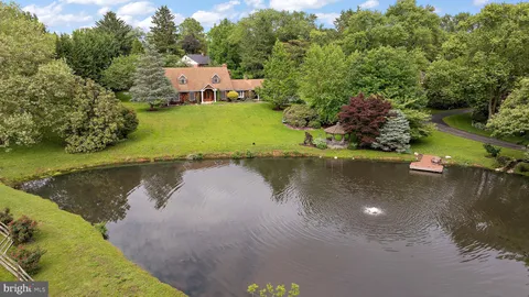 an aerial view of a house with a yard and lake view