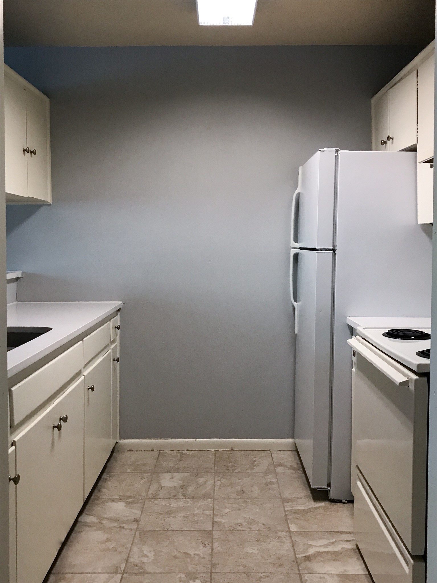 5001 Bull Creek Road, Unit 118 Austin, TX 78731 - Photo 5 of 5 Kitchen featuring white cabinetry, light countertops, and white appliances