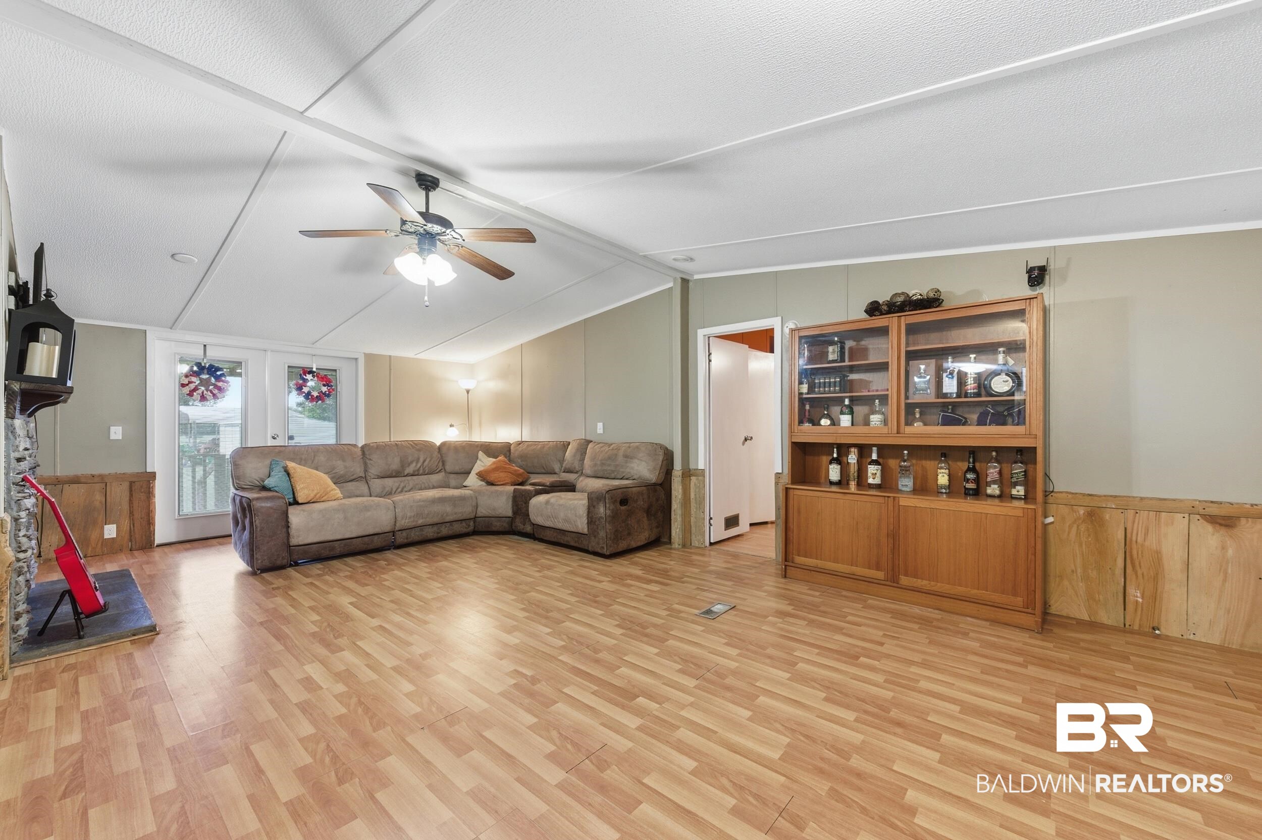 926 Tumbling Lane Atmore, AL 36502 - Photo 14 of 56 Spacious living area featuring wood-finish flooring, a ceiling fan with integrated lighting, and neutral wall tones
