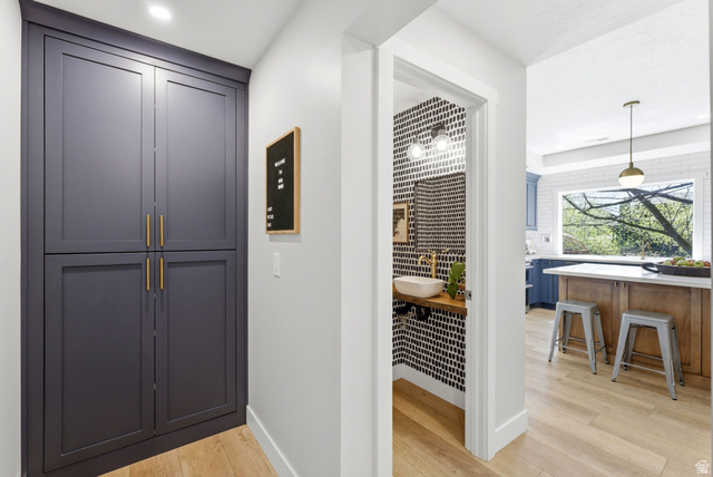 7935 Mustang Loop Road Park City, UT 84098 - Photo 26 of 60 Built-in cabinetry with gold-finish hardware, wood-finish flooring, and a powder room featuring a vessel sink with a gold-finish faucet