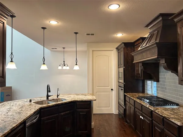 a kitchen with granite countertop a stove and a sink
