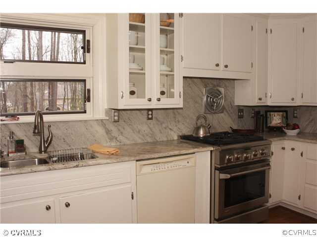 9100 River Road Henrico, VA 23229 - Photo 7 of 24 a kitchen with granite countertop white cabinets and stainless steel appliances