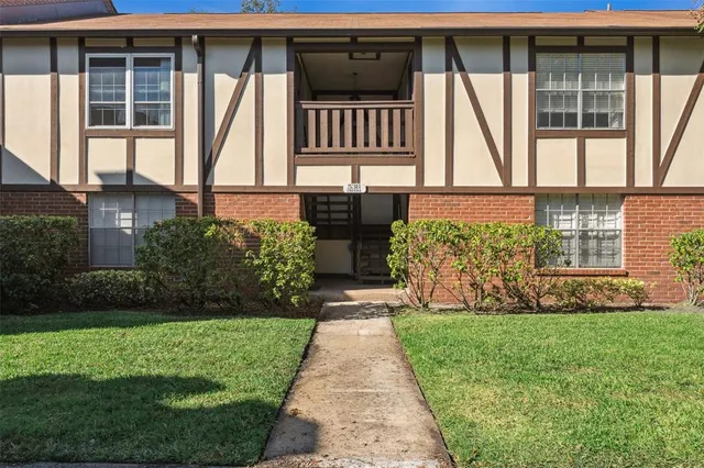 a front view of a house with a yard and potted plants