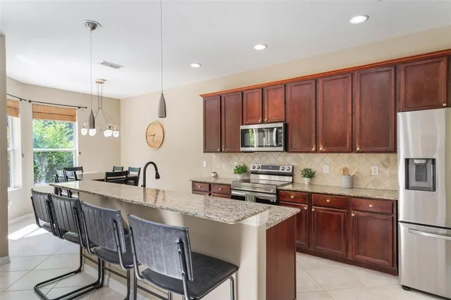 a kitchen with a stove a sink a refrigerator and cabinets