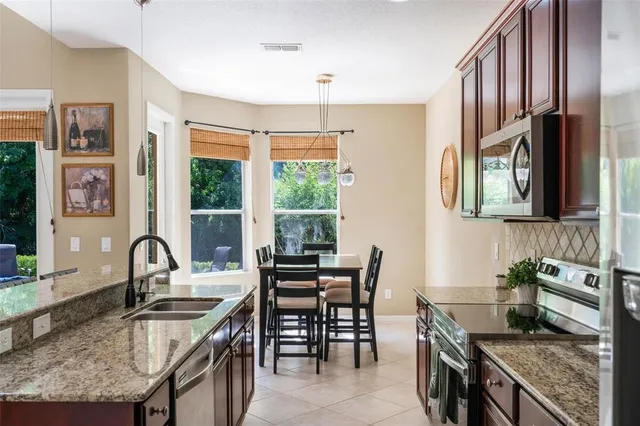 a kitchen with granite countertop sink stove and dining table