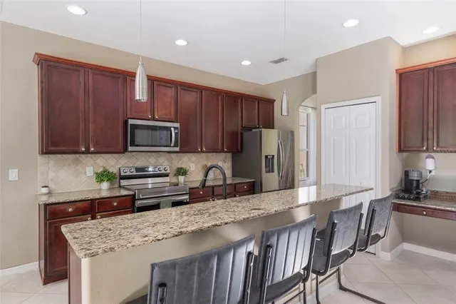 a kitchen with stainless steel appliances granite countertop a stove top oven a sink refrigerator and a granite counter tops