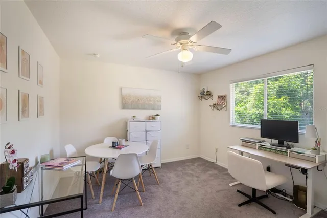 a view of a workspace with furniture and a window