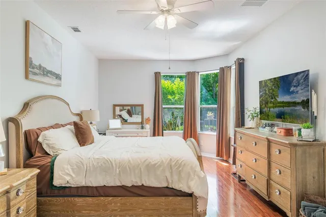 a bedroom with a bed and a flat tv screen on dresser