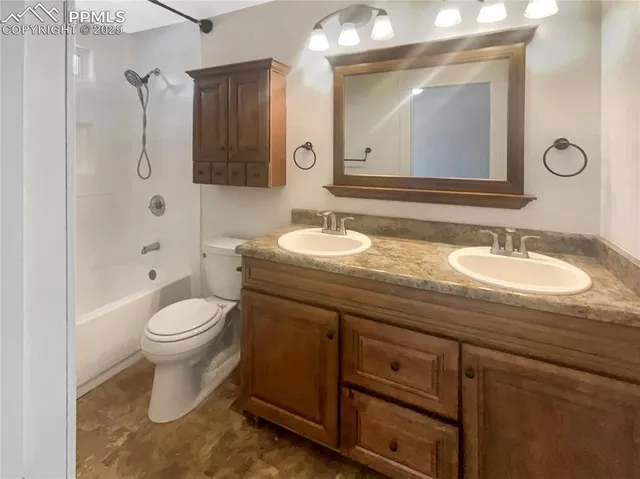 a bathroom with a granite countertop toilet sink and mirror