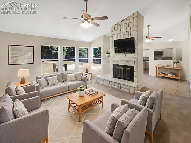 a living room with furniture a fireplace and a flat screen tv