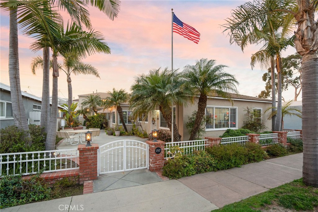 a front view of a house with garden and trees