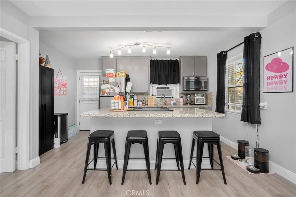 257 5th Street Seal Beach, CA 90740 - Photo 11 of 49 a kitchen with stainless steel appliances granite countertop a table chairs and a refrigerator