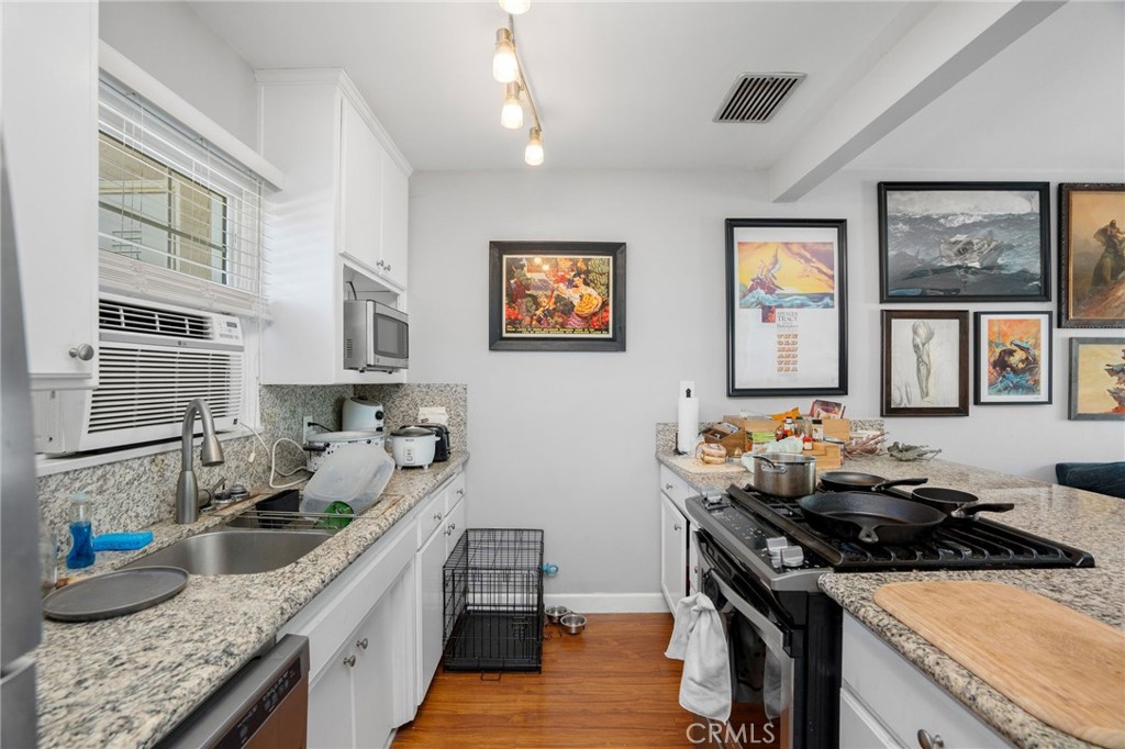257 5th Street Seal Beach, CA 90740 - Photo 18 of 49 a kitchen with granite countertop a stove and a sink