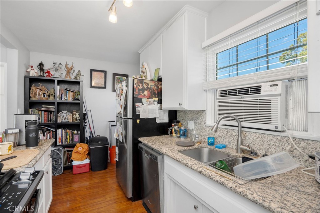 257 5th Street Seal Beach, CA 90740 - Photo 19 of 49 a kitchen with granite countertop lots of clutter and stainless steel appliances