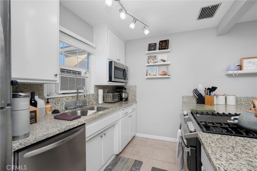 257 5th Street Seal Beach, CA 90740 - Photo 26 of 49 a kitchen with sink cabinets and stove top oven