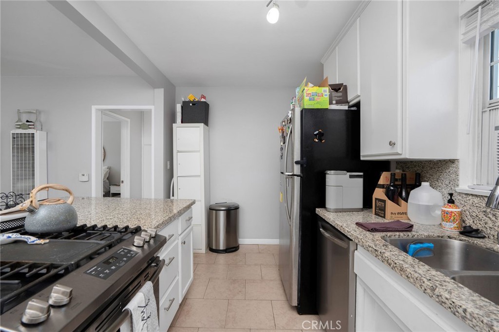 257 5th Street Seal Beach, CA 90740 - Photo 27 of 49 a kitchen with stainless steel appliances granite countertop a stove and a refrigerator