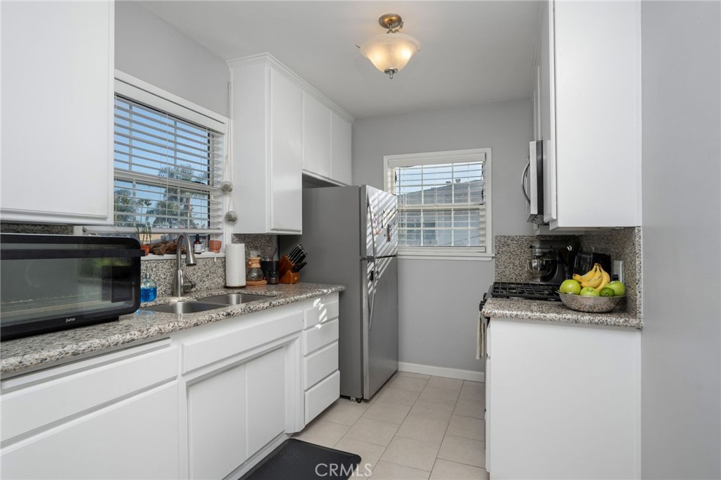 257 5th Street Seal Beach, CA 90740 - Photo 33 of 49 a kitchen with a sink a stove and cabinets