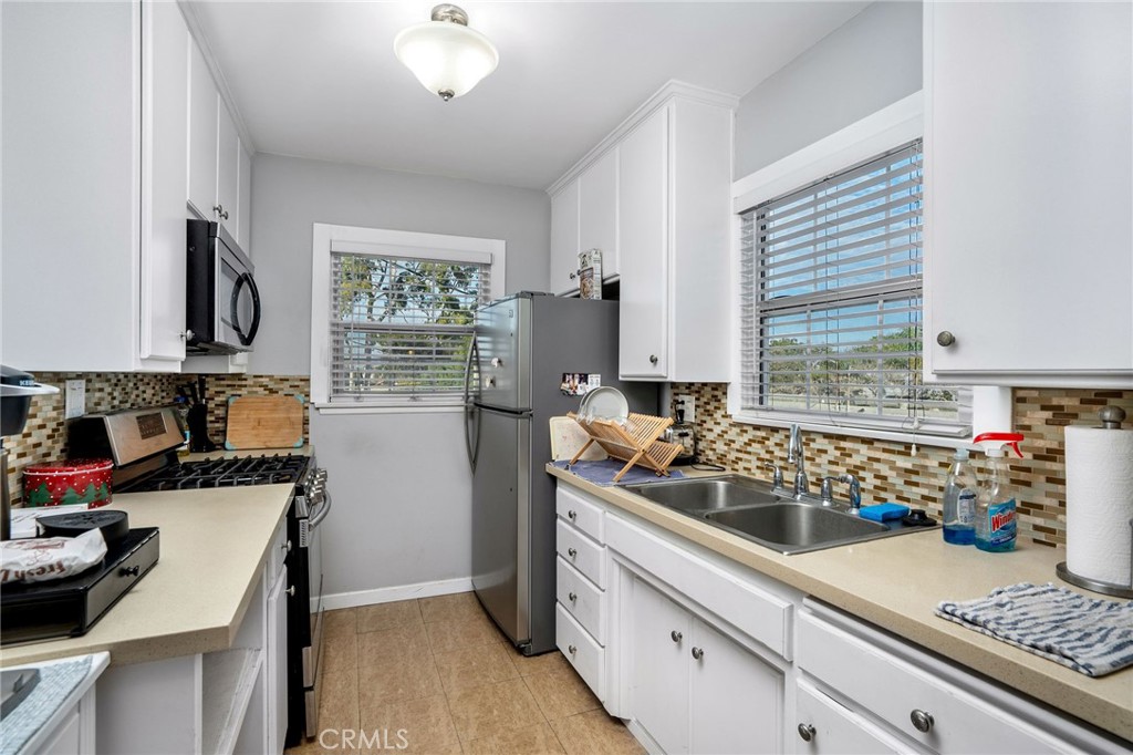 257 5th Street Seal Beach, CA 90740 - Photo 43 of 49 a kitchen with sink a stove and cabinets