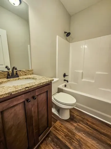 a bathroom with a granite countertop toilet a sink and a bathtub