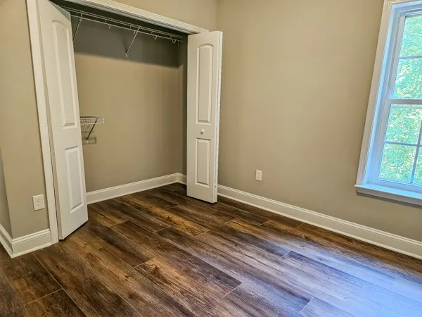 a view of a room with wooden floor and window