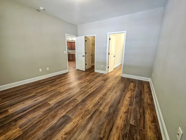 an empty room with wooden floor and closet
