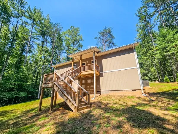 a wooden house with a yard and sitting area