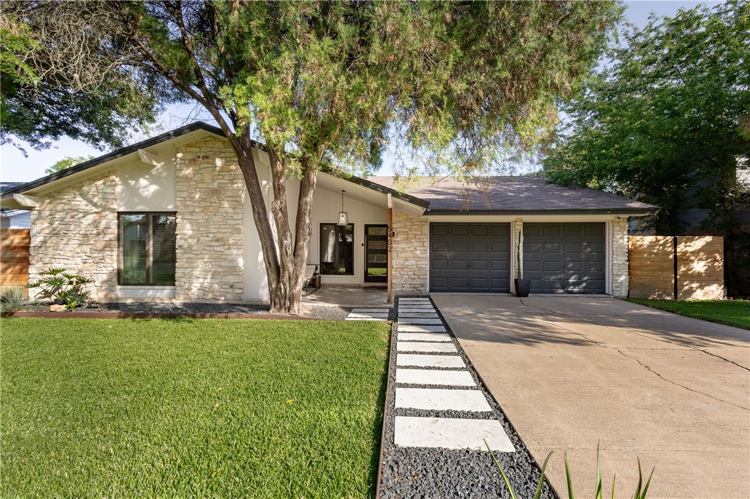 a front view of a house with a garden and yard
