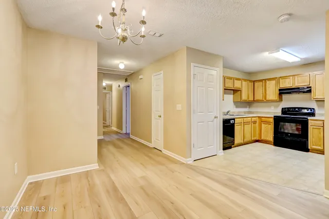 a view of a kitchen with a sink and a refrigerator