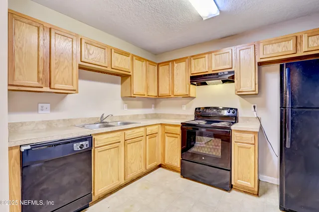 a kitchen with stainless steel appliances granite countertop a refrigerator and cabinets