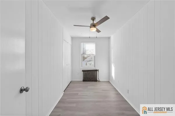 a view of a hallway to a bedroom with wooden floor