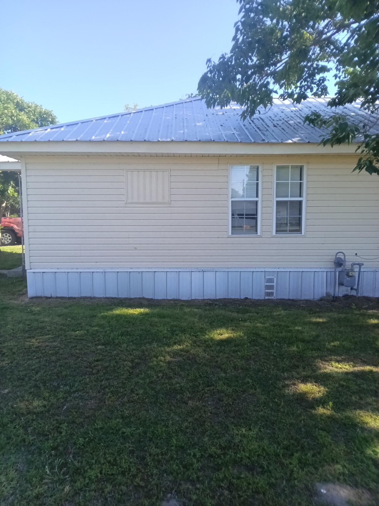 106 South Main Street Ridgely, TN 38080 - Photo 7 of 8 Beige vinyl siding exterior with a pitched metal roof