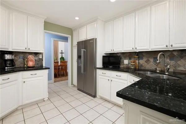 a kitchen with granite countertop white cabinets and stainless steel appliances