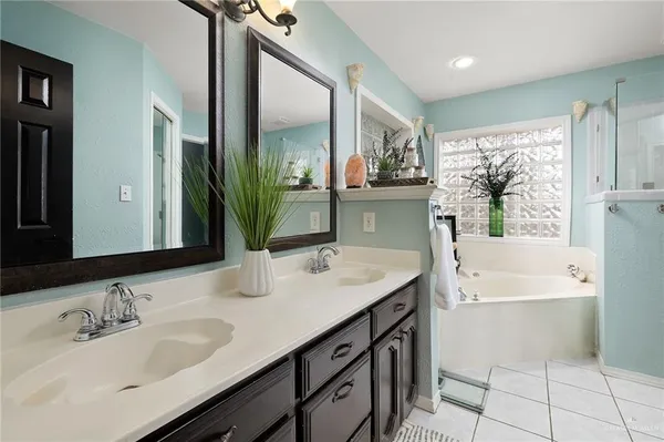 a bathroom with a granite countertop sink mirror and a bathtub